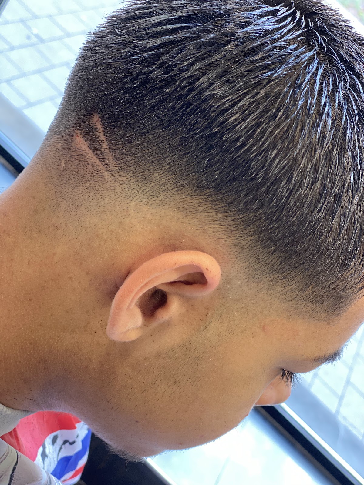 Profil latéral avec cheveux longs lissés vers l'arrière et dégradé